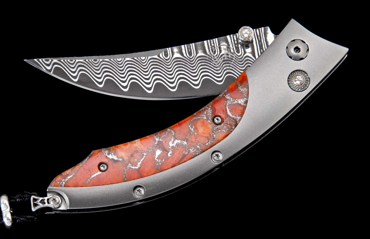 William Henry B 11 Cresting Knife 
Frame Type: Titanium
Blade Type: Damascus Steel
Scale/Inlay: Zinc Matrix Apple Coral
Serial: 2111-0058
Number: 22/50
Gemstones/Embellishments: White Topaz