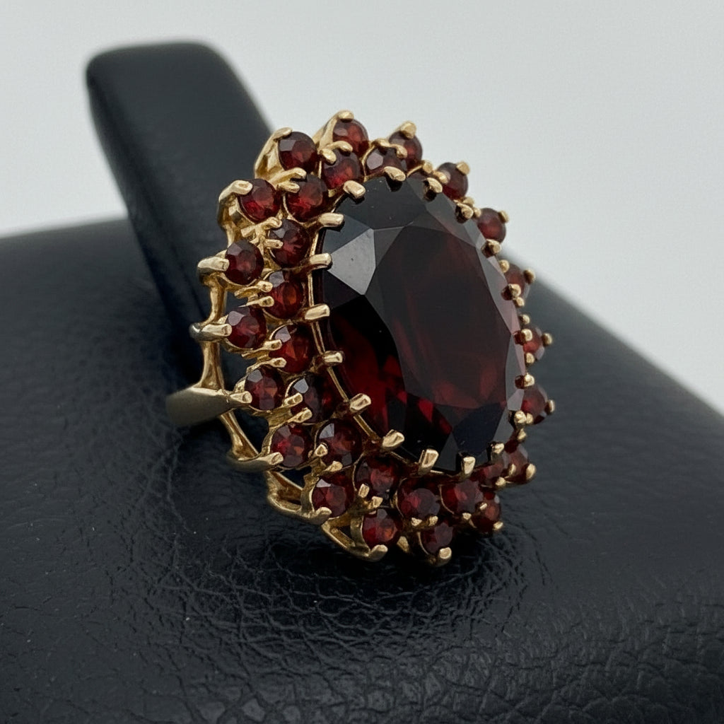 English MK Ring, 1 Garnet Oval 18.00ct, 38 Garnet Rounds 1.90cttw, 9KT Yellow Gold 12.50g. All Weights Estimated.