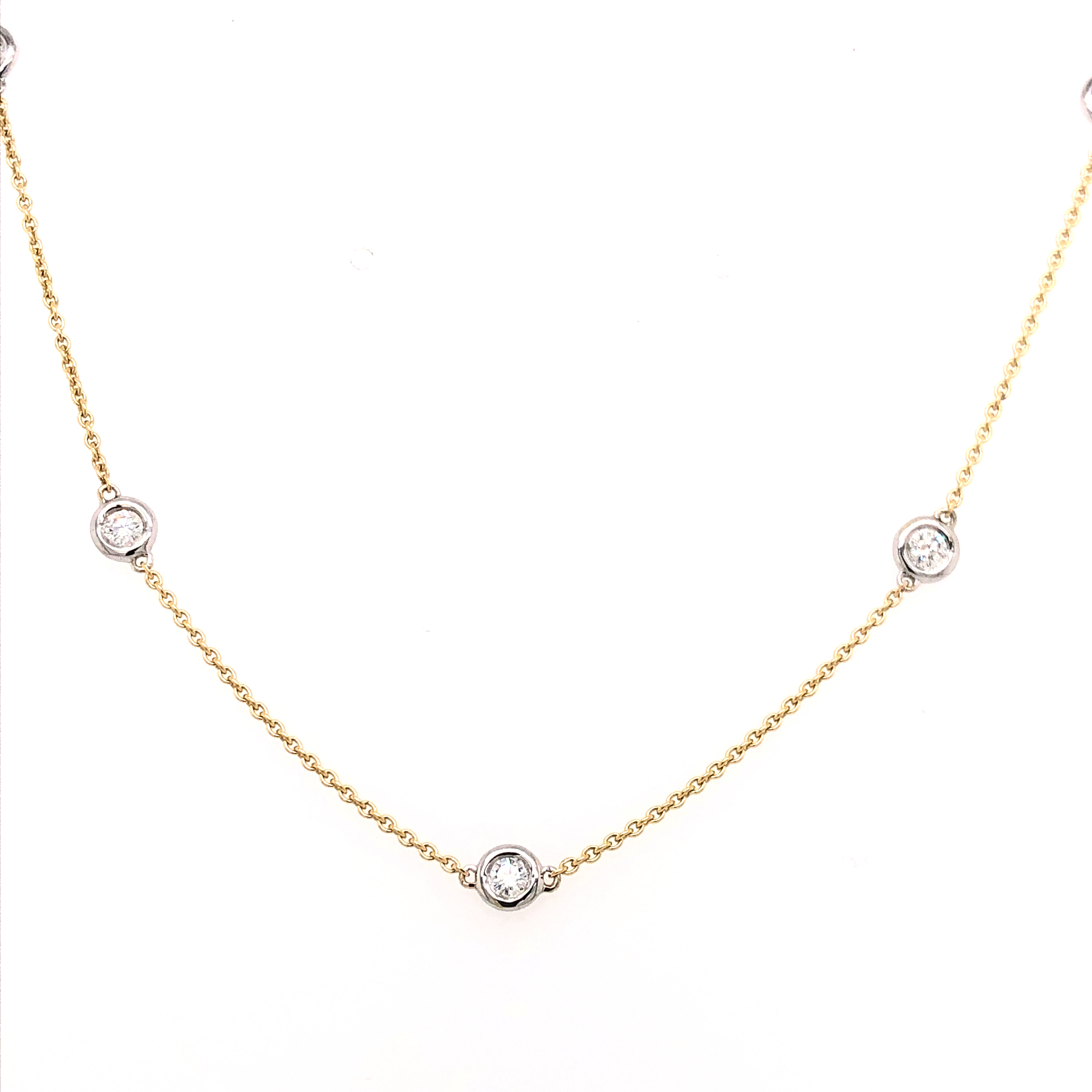 14 Karat yellow gold diamonds by the yard necklace Length 19" with 5=0.30ctw Round Brilliant G SI Diamonds set in white gold.