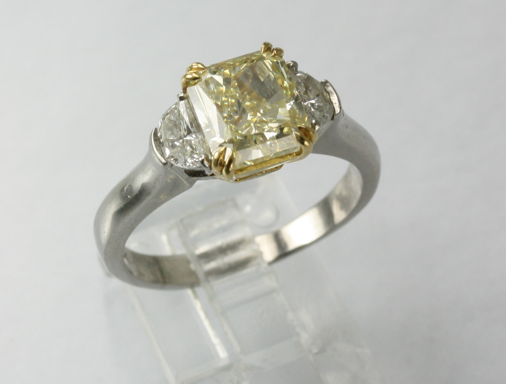 Estate Platinum Diamond Ring Having 1 Radiant Cut Diamond Mounted In An 18 Karat yellow gold Center Weighing 3.02 Carat  VS1-Natural Fancy Light Yellow With 1 Half Moon Diamond Prong Set On Either Side With A Total Weight Of .60 Carat VS2-G