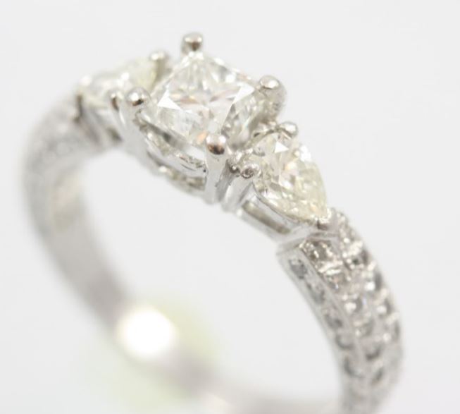 Estate Platinum Diamond Ring Having 1 Princess Cut Diamond 4-Prong Set In The Center Having An Approximate Weight Of .71 Carat Graded SI1 For Clarity And I For Color With 1 Pear Shaped Diamond Prong Set On Either Side And Having 16 Full Cut Diamonds  Pron