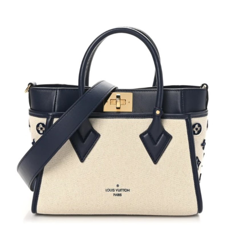 FINAL SALE Louis Vuitton On My Side Monogram Tote         Hardware: Gold color  hook closure  4 outside side pockets  canvas and     smooth navy leather  leather trim  coated canvas lining  leather strap      inside flat pocket  Width:  25 cm/9.84”  Hei