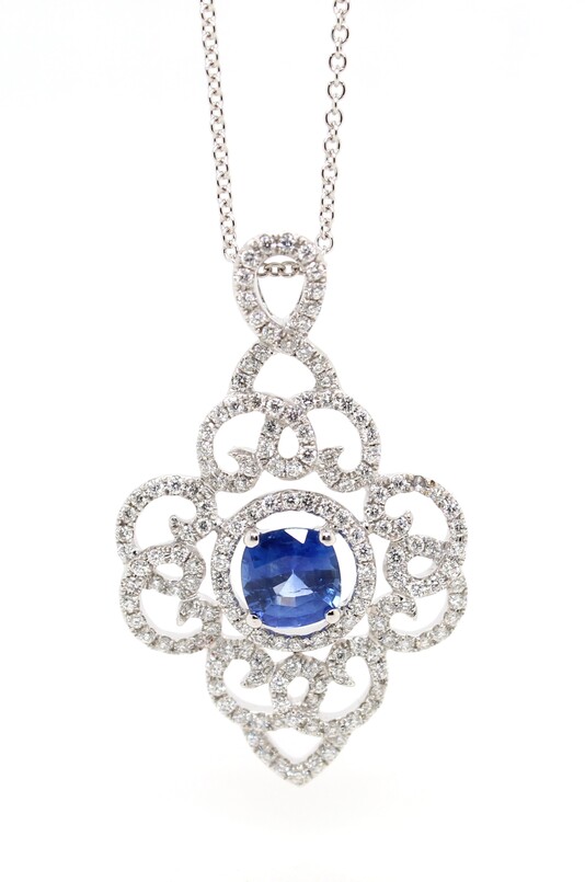 Estate 18 karat white gold blue sapphire and diamond pendant suspended on an 18