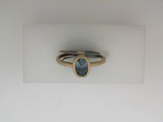 14K YELLOW GOLD SATIN FINISH BEZEL SET RING WITH A .87CT OVAL MONTANA SAPPHIRE