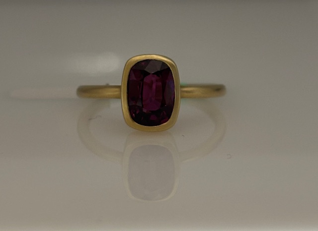 14KT YELLOW GOLD SATIN FINISH BEZEL SET RING WITH A 2.0CT CUSHION CUT PURPLE GARNET