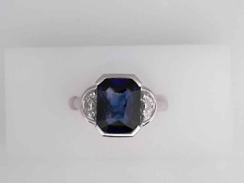 PLATINUM RING WITH A 3.58CT RECTANGLE CUSHION SHAPE SAPPHIRE SET IN A HALF BEZEL WITH 2 .67CTW HALF MOON SI CLARITY & G COLOR DIAMONDSSET IN HALF BEZELS