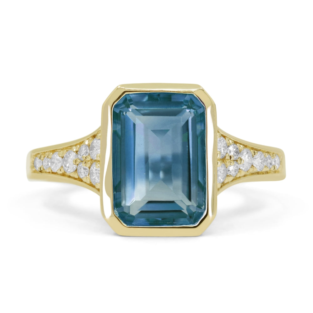 14K YELLOW GOLD 3.17CT BEZEL SET EMERALD CUT LONDON BLUE TOPAZ RING WITH .25CTTW ROUND SI CLARITY & H COLOR DIAMONDS SET DOWN THE SHANK