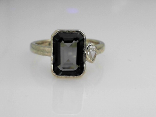14K GREEN GOLD RING WITH A BEZEL SET EMERALD CUT LONDON BLUE TOPAZ AND A .10CT SI CLARITY &G COLOR BEZEL SET PEAR SHAPED DIAMOND