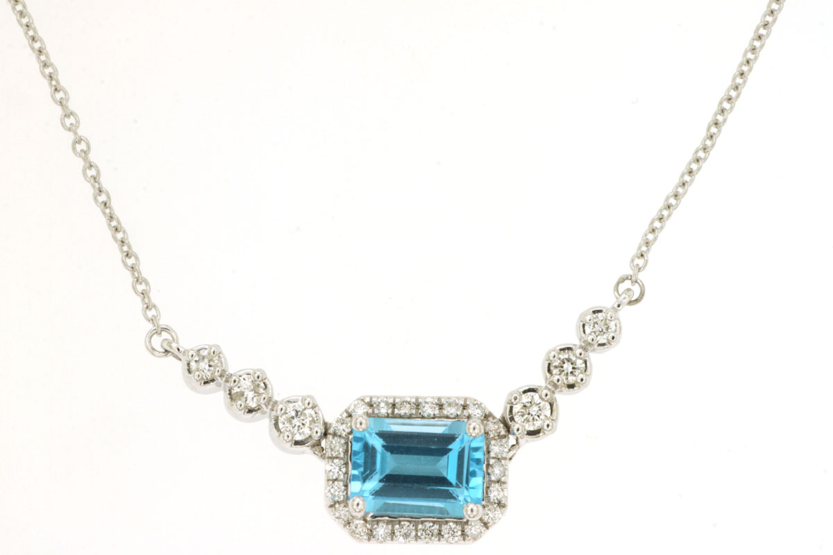 14K WHITE GOLD NECKLACE WITH A 1.10CT EMERALD CUT BLUE TOPAZ AND .205CTTW ROUND I1 CLARITY & HI COLOR DIAMONDS SET IN THE HALO AND UP THE CHAIN