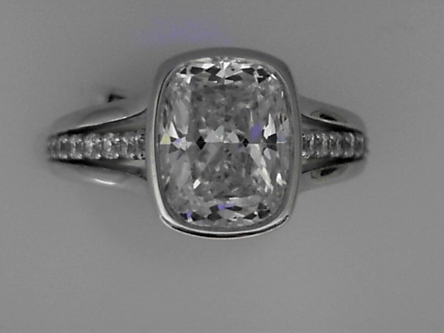 SILVER CZ SAMPLE BEZEL SET SEMI MOUNTING WITH.21CTTW ROUNDS SET IN THE CENTER OF THE TRIPLE TAPERED SHANK FOR A 2.5CT CUSHION CUT CENTER